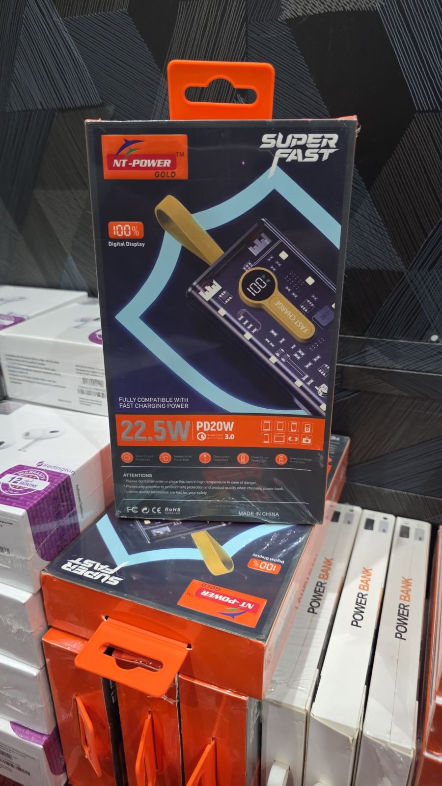NT-Power Gold 10000mAh power bank with a transparent, tech-style casing, a gold-colored carrying strap, and a digital percentage display
